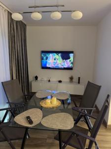 a dining room with a table with chairs and a tv at The cozy escape in Satu Bucovei