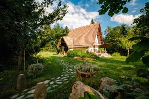 a small house with a stone path in front of it at Sanjska Hiša Vojsko in Idrija