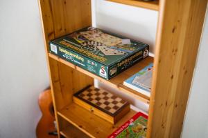 a book shelf with two books and a chess board at Sanjska Hiša Vojsko in Idrija