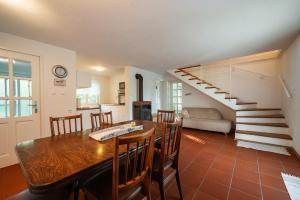 a kitchen and dining room with a table and a staircase at Sanjska Hiša Vojsko in Idrija