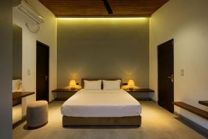 a bedroom with a large bed and two lamps at The Plunge by Duo Escapes in Gonahena
