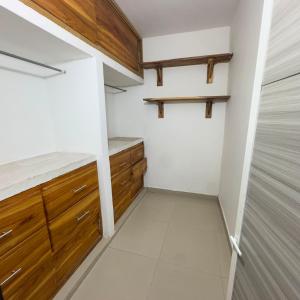 a walk in closet with wooden cabinets and tile floors at Hotel Habitaciones D y Mar in Tolú