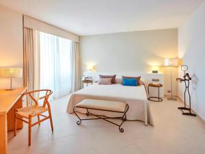 a large white bedroom with a bed and a desk at Hotel Tres Torres in Santa Eularia des Riu +64 photos