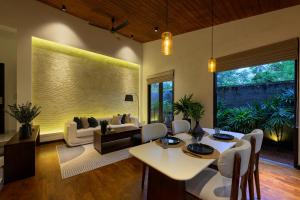 a living room with a couch and a table and chairs at The Plunge by Duo Escapes in Gonahena