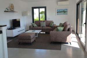 a living room with a couch and chairs and a tv at Na Baía in Salir de Porto