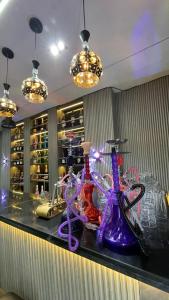 a counter with purple and purple glass bottles on it at X-ones place command in Meran