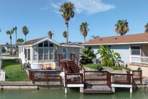 a house with a dock in the water at Bonnet Sea Cottage on the water- LIV Resort in Port Isabel