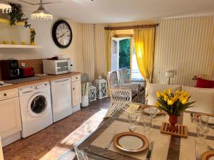 a kitchen with a table with yellow flowers on it at Jardin et Hotel Particulier in Bayeux