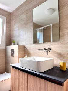 ein Badezimmer mit einem weißen Waschbecken und einem Spiegel in der Unterkunft Elea residence in Elaiokhórion + 12 Fotos