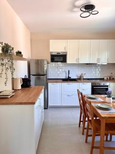 eine Küche mit weißen Schränken und einem Tisch mit Stühlen in der Unterkunft Elea residence in Elaiokhórion
