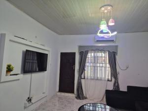a living room with a black door and a window at D-vine Apartments & Hotels in Benin City +4 photos