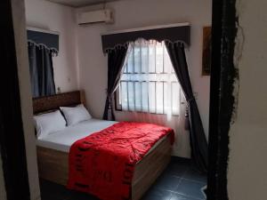 a small bedroom with a bed with a window at D-vine Apartments & Hotels in Benin City