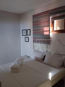 a bed in a white room with a window at Perfect View House in Sotír