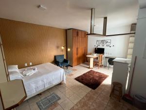 a bedroom with a bed and a table and a desk at Residencial Alfa in Canoas