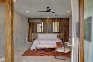 a bedroom with a white bed and a chair at NANANA Hotel de Mar - Solo Adultos in Puerto Escondido +63 photos