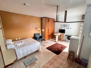 a bedroom with a bed and a desk and a table at Residencial Alfa in Canoas