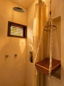 a bathroom with a basket hanging from the wall at Shamalay - Nomad Experience in Bacalar +35 photos