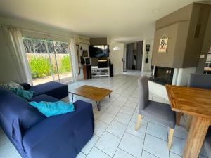 a living room with a blue couch and a table at Villa Cazaux in La Teste-de-Buch +16 photos