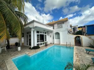 a swimming pool in front of a house at Rayan Tourist Villa in Flic-en-Flac
