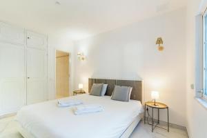 a bedroom with a white bed with two towels on it at New Horizon Algarve in Almancil