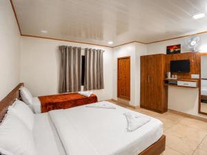 a hotel room with two beds and a television at Lake Residency Ooty in Ooty