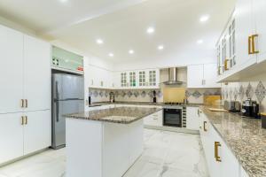 a kitchen with white cabinets and granite counter tops at New Horizon Algarve in Almancil
