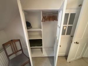 a walk in closet with a chair and a door at Cotford Cottage in Sidmouth