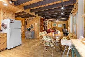 a kitchen and dining room with a white refrigerator at Amazing All-Season Sprucewold Cabin w/ Private Beach Club Access Dog-friendly in Boothbay Harbor