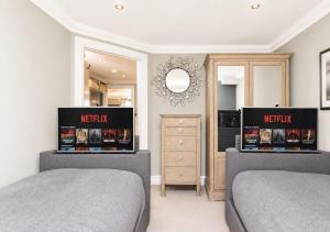 a bedroom with two beds and a mirror at Crystal View by the Sea in Carbis Bay