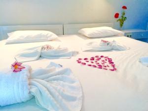 Una cama blanca con dos artículos de bebé. en Hotel Kleopatra, en Stalós