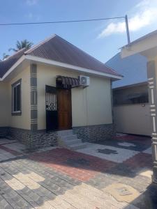 a small house with a door and a porch at Angels Lodge in Dar es Salaam
