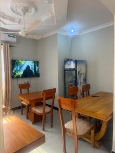 a dining room with a wooden table and chairs at Angels Lodge in Dar es Salaam