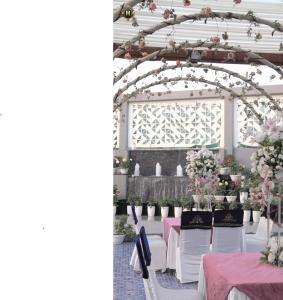 a set up for a wedding with tables and flowers at Hotel Millennium in Hisār