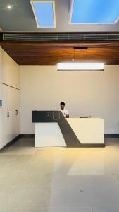 a man sitting at a desk in a room at Hotel Millennium in Hisār