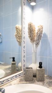 a mirror over a sink with flowers in a bathroom at Villa Twins in Myrina +25 photos