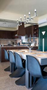 a kitchen with a large table and blue chairs at Villa Twins in Myrina