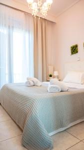 a bedroom with a large bed with a chandelier at Villa Twins in Myrina