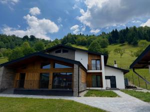 a house with a large window on a hill at Akacia Chalet in Moieciu de Jos