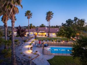 an aerial view of a house with a swimming pool and palm trees at Hilltop Oasis in Templeton