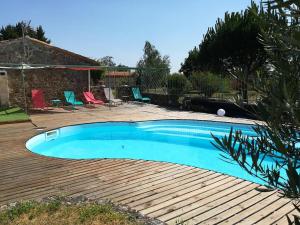 a swimming pool in a yard with a wooden deck at Domaine Saint Claude - Chambres d'hôtes de charme in Malleval