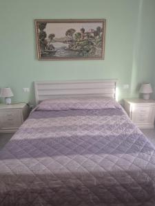 a bedroom with a bed with a purple comforter at Le Dune per 4 in Silvi Marina