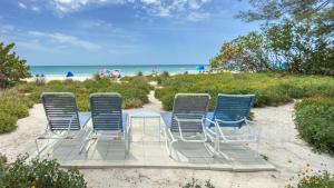 a group of chairs sitting on the beach at Bamboo Apartments in Holmes Beach