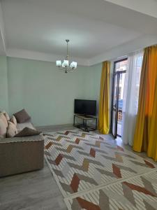 a living room with a couch and a television at Baytur-Yilla09 in Bosteri