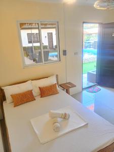 a bedroom with a white bed with a tray on it at V Hostel Galera in Puerto Galera +25 photos