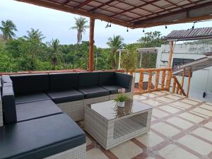 a patio with a couch and a table at V Hostel Galera in Puerto Galera