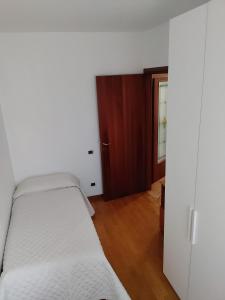 a bedroom with a white bed and a closet at RAMERAHouse in Mareno di Piave
