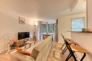 a living room with a couch and a tv at Charmant appartement proche Val Europe Disneyland paris in Torcy