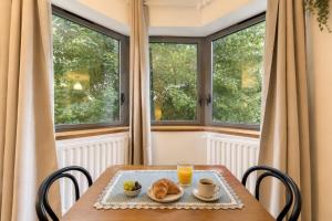 a table with a plate of food and two windows at Charmant appartement proche Val Europe Disneyland paris in Torcy