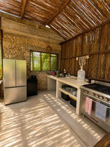a kitchen with a refrigerator and a stove at Shamalay - Nomad Experience in Bacalar