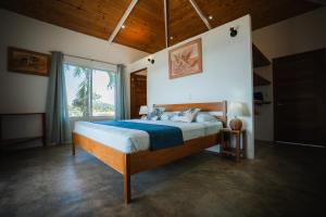 a bedroom with a bed and a large window at Lodge Las Estrellas de Samara - Ocean View in Sámara